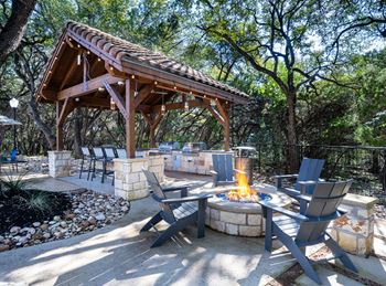 Outdoor pavilion with fire pit and adirondack chairs